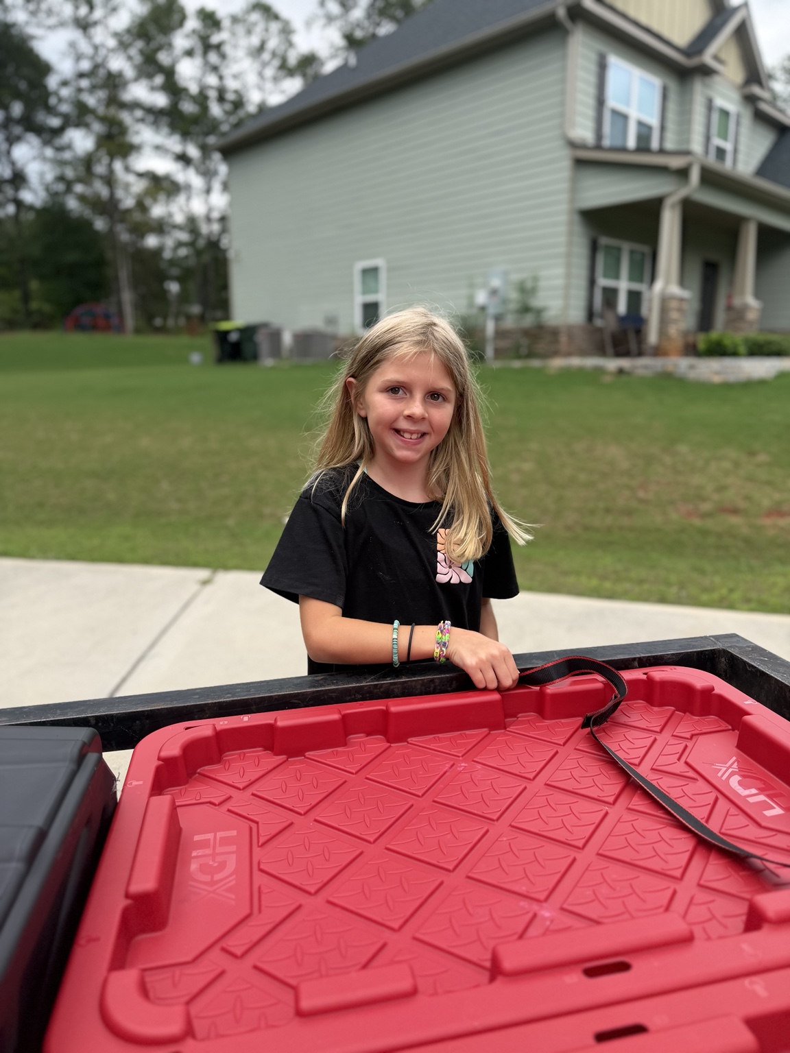 Emmarie helping with a red tote lid